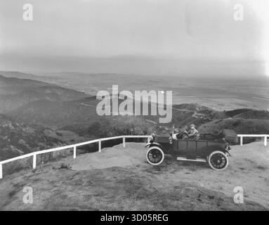 Homme assis dans sa voiture décapotable à Lookout Mountain surplombant Hollywood 1913 Banque D'Images