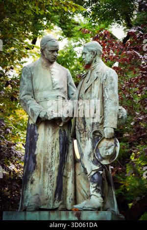Cologne, Allemagne 17 octobre 2025 : statue en bronze du réformateur social catholique Adolph Kolping (1813-1865) et d'un compagnon à Kolpingplatz à Cologne, se Banque D'Images