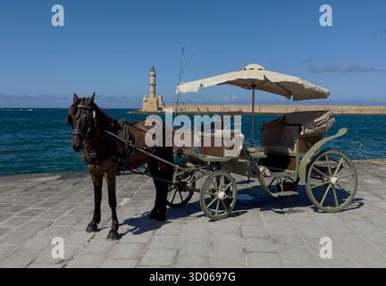 Cheval et buggy avec phare dans le vieux port vénitien de la Canée - Crète, Grèce Banque D'Images