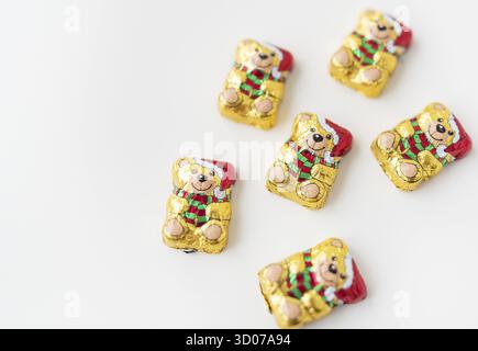 Rivne, Ukraine -18 décembre 2022 : ours en peluche au chocolat dans un paquet de Noël sur fond blanc. Charmant chocolat Lindt et un cadeau délicieux Banque D'Images