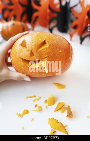 Octobre 31.Fête d'Halloween.Le visage sculpté d'une citrouille sur fond orange et noir Banque D'Images