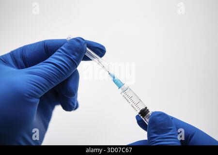 Main du médecin dans des gants bleus en préparation pour la vaccination. Coronavirus, vaccin contre le covid-19 Banque D'Images