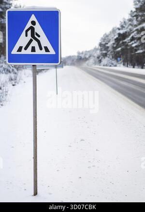 Belle route d'hiver au milieu de la forêt avec des panneaux et le passage de zébra, passage piéton Banque D'Images