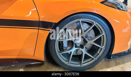 Voiture de sport orange avec roues en alliage, détail du véhicule de performance, conception automobile moderne, carrosserie de voiture de course de rue, style de réglage de haute qualité Banque D'Images