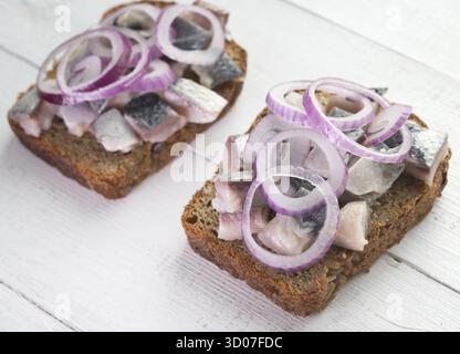 Deux sandwiches ouverts avec le hareng et l'oignon rouge Banque D'Images