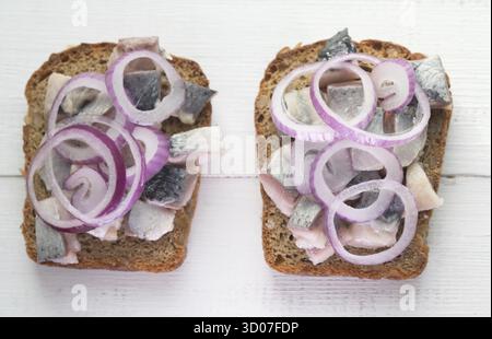 Deux sandwiches ouverts avec le hareng et l'oignon rouge Banque D'Images