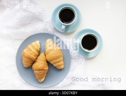 Deux tasses de café avec des croissants sur le fond de dentelle inscription Bonjour Banque D'Images