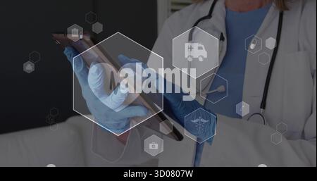 Tenant l'infirmière dans des gants bleus avec stéthoscope tapoter la tablette à la clinique, avec des icônes hexagonales, espace de copie Banque D'Images