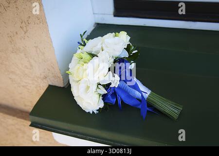Beau bouquet de mariage de roses blanches en fleurs beiges sur un rebord de fenêtre Banque D'Images