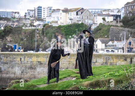 DATE DE CORRECTION RETRANSMISE les paddleboarders du Newquay Activity Centre entrent dans l'esprit d'Halloween après une pagaie tôt le matin à l'aube à travers Newquay Bay à Cornwall, où les amateurs de sports nautiques préparent des tenues pour une semaine de célébration des activités dans la ville balnéaire pendant Spooky Newquay pendant les vacances d'Halloween, à partir du samedi 25 octobre. Date de la photo : mercredi 22 octobre 2025. Banque D'Images