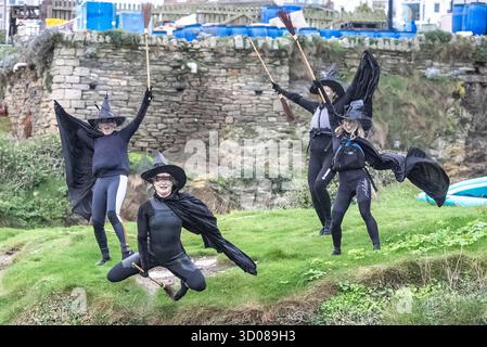 DATE DE CORRECTION RETRANSMISE les paddleboarders du Newquay Activity Centre entrent dans l'esprit d'Halloween après une pagaie tôt le matin à l'aube à travers Newquay Bay à Cornwall, où les amateurs de sports nautiques préparent des tenues pour une semaine de célébration des activités dans la ville balnéaire pendant Spooky Newquay pendant les vacances d'Halloween, à partir du samedi 25 octobre. Date de la photo : mercredi 22 octobre 2025. Banque D'Images