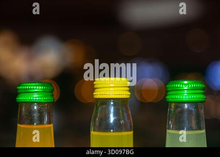Dessus des bouteilles en verre avec des bouchons en fer fermés sur fond flou dans une pièce sombre avec des lumières Banque D'Images