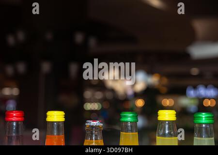Dessus des bouteilles en verre avec des bouchons en fer fermés sur fond flou dans une pièce sombre avec des lumières Banque D'Images