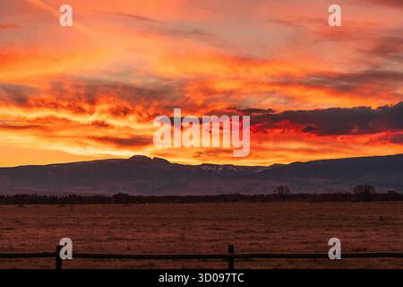 Lever de soleil vibrant sur la chaîne de Teton dans les montagnes Rocheuses, près de Moose, Wyoming. Le ciel présente des teintes spectaculaires d'orange et de rouge Banque D'Images