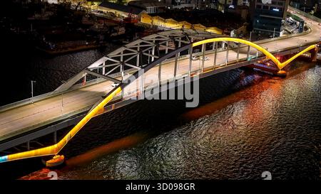 Pont de la ville de Busan illuminé la nuit, reflétant les lumières vibrantes sur la surface du fleuve qui coule Banque D'Images