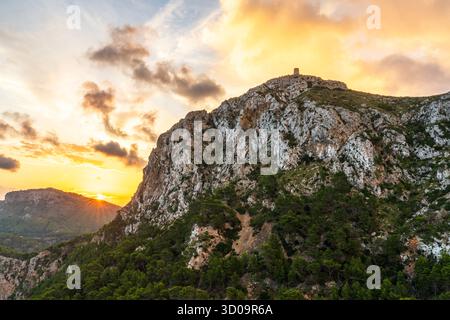 Vue panoramique au lever du soleil de la tour de guet historique Formentor sur une colline à Majorque, Espagne. Lumière paisible tôt le matin sur les falaises côtières et la pierre ancienne Banque D'Images