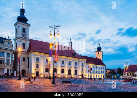 Roumanie, région de Transylvanie, Sibiu, Piata Mare ou Grand Square dans le centre de la vieille ville, église jésuite du 18ème siècle ou église catholique de la Sainte Trinité Banque D'Images