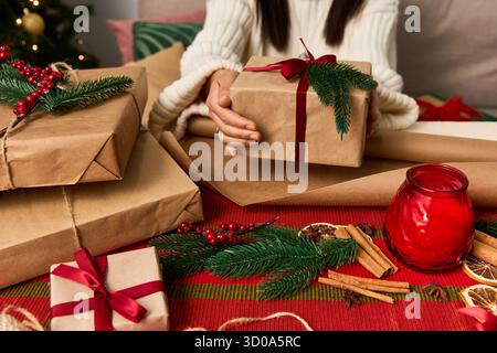 Emballage de cadeaux avec esprit de vacances et décorations douillettes dans un cadre chaleureux et festif. Banque D'Images