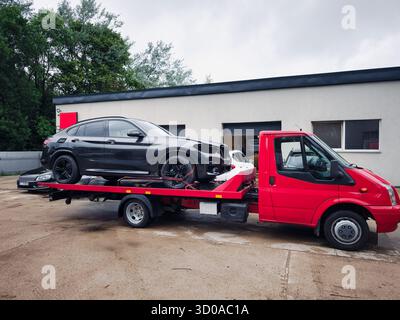 Véhicule de croisement accidenté transporté sur la plate-forme d'une dépanneuse après un accident de la route Banque D'Images
