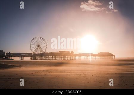 Blackpool Central Pier et Ferris Wheel silhouettent contre un soleil matinal éclatant Banque D'Images