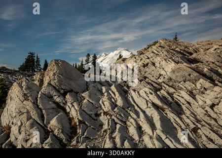WA28639-00...WASHINGTON - lumière matinale sur des rochers fracturés le long de la crête de Kushan avec le mont Baker au loin. Banque D'Images