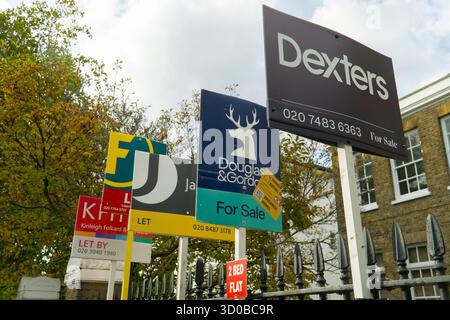 Londres, Royaume-Uni. 22 octobre 2025. Les conseils d'agent immobilier à l'extérieur d'un bâtiment à Brixton, au sud de Londres, annoncent différents appartements comme à vendre, à louer ou à louer par différentes agences. Il y a une pénurie de logements à Londres et les loyers commerciaux sont inabordables pour beaucoup. Avec l'annonce d'aujourd'hui que l'inflation était stable à 3,8%, on peut espérer que les taux d'intérêt pourraient baisser bientôt. Crédit : Anna Watson/Alamy Live News Banque D'Images
