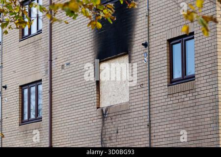 Glasgow, Écosse, Royaume-Uni. 22 octobre 2025. Les suites d'un incendie qui a éclaté dans un appartement sur Hughenden Lane dans le West End de Glasgow lundi soir. Des traces de suie noire sont visibles sur les murs extérieurs, et des débris restent dispersés sur le sol alors que les recherches sur la cause de l'incendie se poursuivent. Crédit : Jacob Hughes/Alamy Live News Banque D'Images