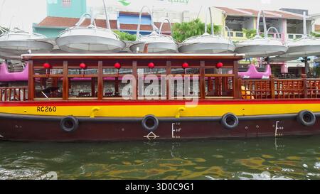 Un bateau à aubes attendant les passagers à Clarke Quay à Singapour, amarré le long du front de mer animé avec des bâtiments colorés au bord de la rivière à l'arrière-plan Banque D'Images