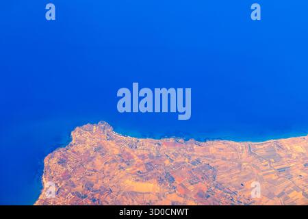 Côte de l'île de Kos en Grèce, avec les eaux bleues profondes de la mer Égée rencontrant le terrain de l'île. La terre est un mélange de zones urbaines et agricoles f Banque D'Images