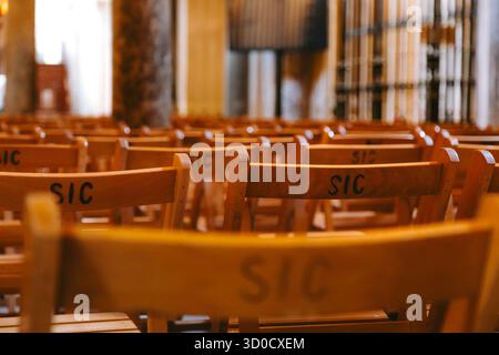 Rangées de chaises en bois vides soigneusement disposées pour l'événement à l'intérieur de l'espace architectural de la cathédrale de cordoue, en espagne reflétant l'ordre et l'anticipation Banque D'Images