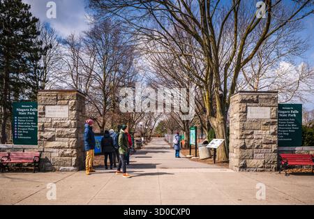 Niagara Fall, NY, États-Unis - 19 mars 2019 : visiteurs debout à côté de piliers de pierre à l'entrée du parc national de Niagara Falls. Banque D'Images