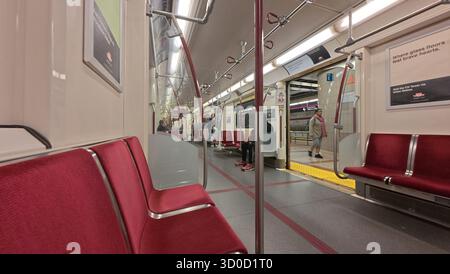 Toronto, ON, Canada - 18 octobre 2025 : L'intérieur d'une voiture de métro de transport en commun avec des sièges rouges est presque vide en attendant à une gare. Banque D'Images
