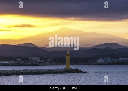 La vue sur le mont Hallasan avec le phare du port de seongsan pris d'un ferry pendant les heures de coucher du soleil. Île de Jeju, Corée du Sud Banque D'Images