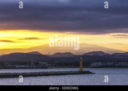 La vue sur le mont Hallasan avec le phare du port de seongsan pris d'un ferry pendant les heures de coucher du soleil. Île de Jeju, Corée du Sud Banque D'Images