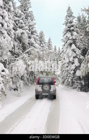 04 octobre 2025 voiture sur le chemin enneigé à travers la forêt enneigée dans les montagnes de Bjelasica, Kolasin, Monténégro Banque D'Images