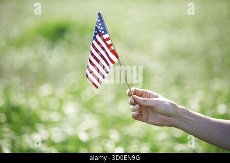 Human hand holding US flag pour le jour de l'indépendance Banque D'Images