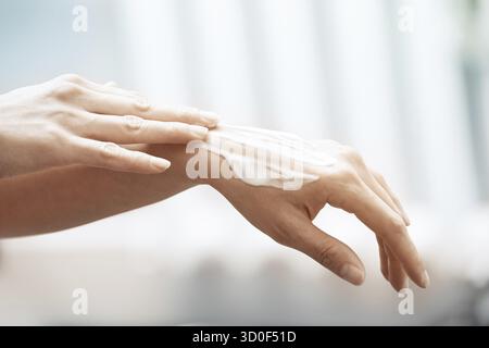 L'application de crème hydratante femme sur les mains Banque D'Images