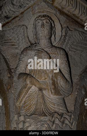 Passez par ici … Sculpté sur pilier d’angle, l’homme ailé aux yeux noirs symbolisant Saint Matthieu L’évangéliste utilise la main d’araignée pour pointer vers le bas une promenade du cloître roman du XIIe siècle de la cathédrale de nouveaux-Sauveur à Aix-en-Provence, Provence-Alpes-Côte d’Azur, sud de la France. Les emblèmes traditionnels des évangélistes et écrivains de Gospel Mark, Luke et John sont également sculptés ici. Banque D'Images
