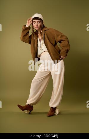 Une jeune femme confiante prend une pose à la mode dans une tenue élégante avec des accessoires uniques. Banque D'Images
