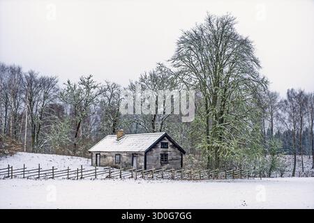 Ancien chalet en bois dans une campagne enneigée Banque D'Images