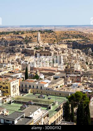 Vue aérienne d'anciens bâtiments en pierre en cascade sur la colline accidentée, baignée de lumière chaude du soleil, créant une tapisserie intemporelle d'histoire et d'architecture, Matera, Basilicate, Italie. Banque D'Images