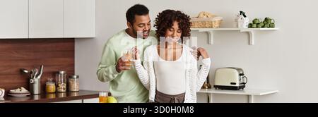 Un couple noir aimant partage un moment tendre à la maison alors qu'ils se préparent pour leur bébé, bannière Banque D'Images