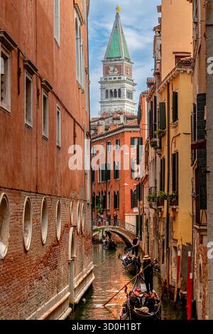 Un canal étroit dans le sestiere de San Marco rempli de gondoles avec Campanile de St Marc au loin, Venise, Italie Banque D'Images