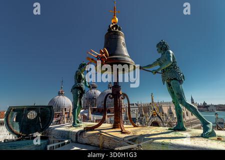Les deux statues géantes en bronze, connues sous le nom de Maures, frappent la cloche au sommet de la Torre dell'Orologio ou Tour de l'horloge sur la place Saint-Marc à Venise Banque D'Images