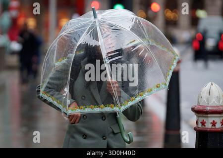 Les Londoniens négocient des vents forts de la tempête Benjamin dans la ville de Londres, le quartier financier de la capitale, le 23 octobre 2025, à Londres, en Angleterre. Benjamin a causé des pannes de courant dans l'est de l'Angleterre après que le met Office a émis un avertissement météorologique, estimant la vitesse du vent jusqu'à 70 mph (113 km/h). Banque D'Images