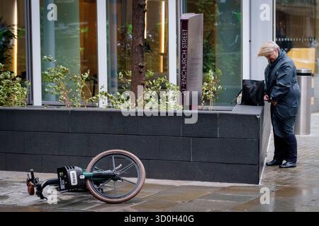 Les Londoniens négocient des vents forts de la tempête Benjamin dans la ville de Londres, le quartier financier de la capitale, le 23 octobre 2025, à Londres, en Angleterre. Benjamin a causé des pannes de courant dans l'est de l'Angleterre après que le met Office a émis un avertissement météorologique, estimant la vitesse du vent jusqu'à 70 mph (113 km/h). Banque D'Images