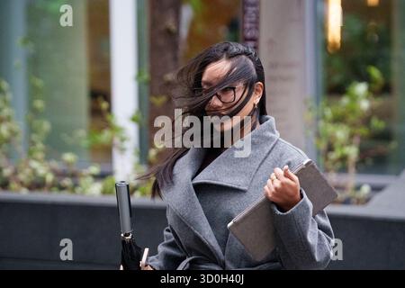 Les Londoniens négocient des vents forts de la tempête Benjamin dans la ville de Londres, le quartier financier de la capitale, le 23 octobre 2025, à Londres, en Angleterre. Benjamin a causé des pannes de courant dans l'est de l'Angleterre après que le met Office a émis un avertissement météorologique, estimant la vitesse du vent jusqu'à 70 mph (113 km/h). Banque D'Images