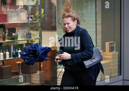 Les Londoniens négocient des vents forts de la tempête Benjamin dans la ville de Londres, le quartier financier de la capitale, le 23 octobre 2025, à Londres, en Angleterre. Benjamin a causé des pannes de courant dans l'est de l'Angleterre après que le met Office a émis un avertissement météorologique, estimant la vitesse du vent jusqu'à 70 mph (113 km/h). Banque D'Images
