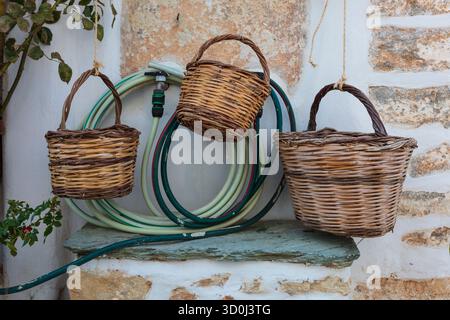 Paniers et tuyaux à l'extérieur d'une maison dans le village de Chora - Folegandros Island, Cyclades Islands, Grèce Banque D'Images