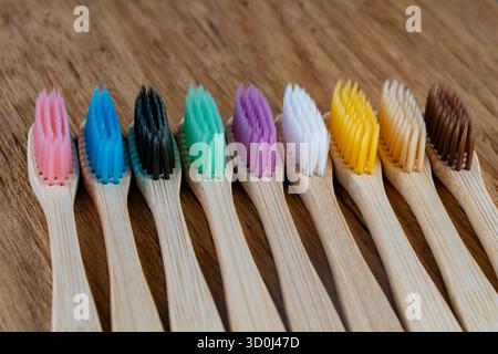 Ensemble de brosses à dents en bambou multicolores sur fond en bois, gros plan. Zéro déchet, sans plastique, concept de produit organique respectueux de l'environnement Banque D'Images